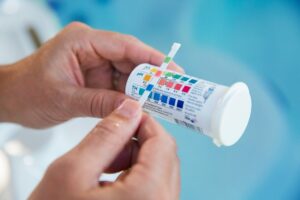 man checking hot tub alkalinity and pH using pH text strips
